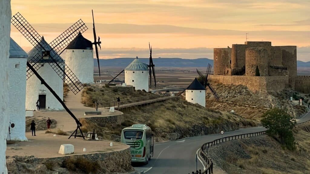 some of the windmills of consuegra in la mancha with the castle in the background