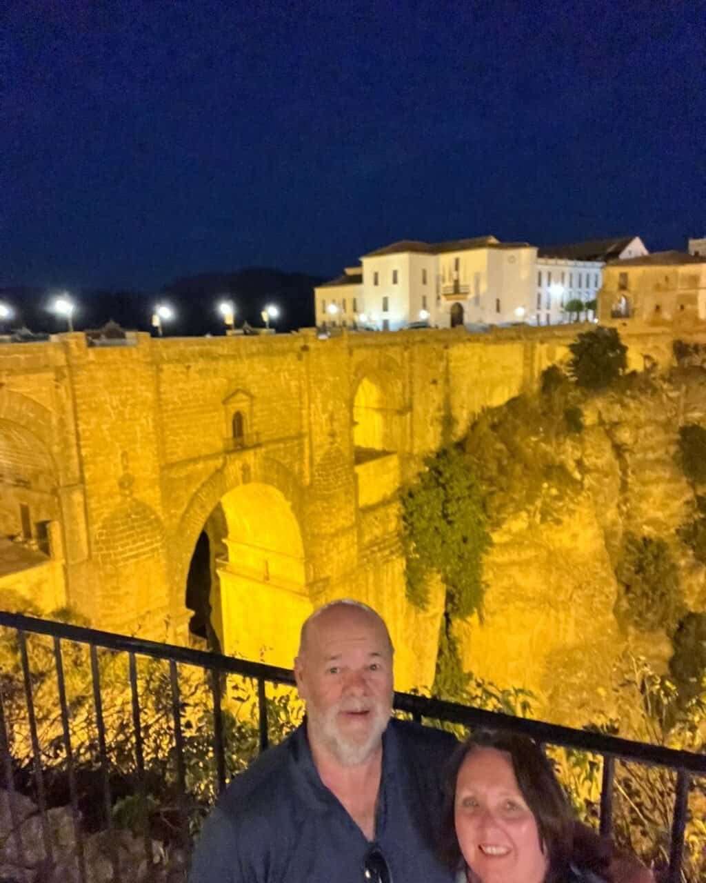 couple in front of the ronda bridge at night
