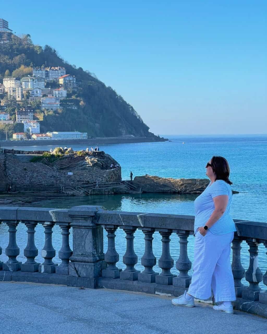 woman on the promenade overlooking la concha beach san sebastian