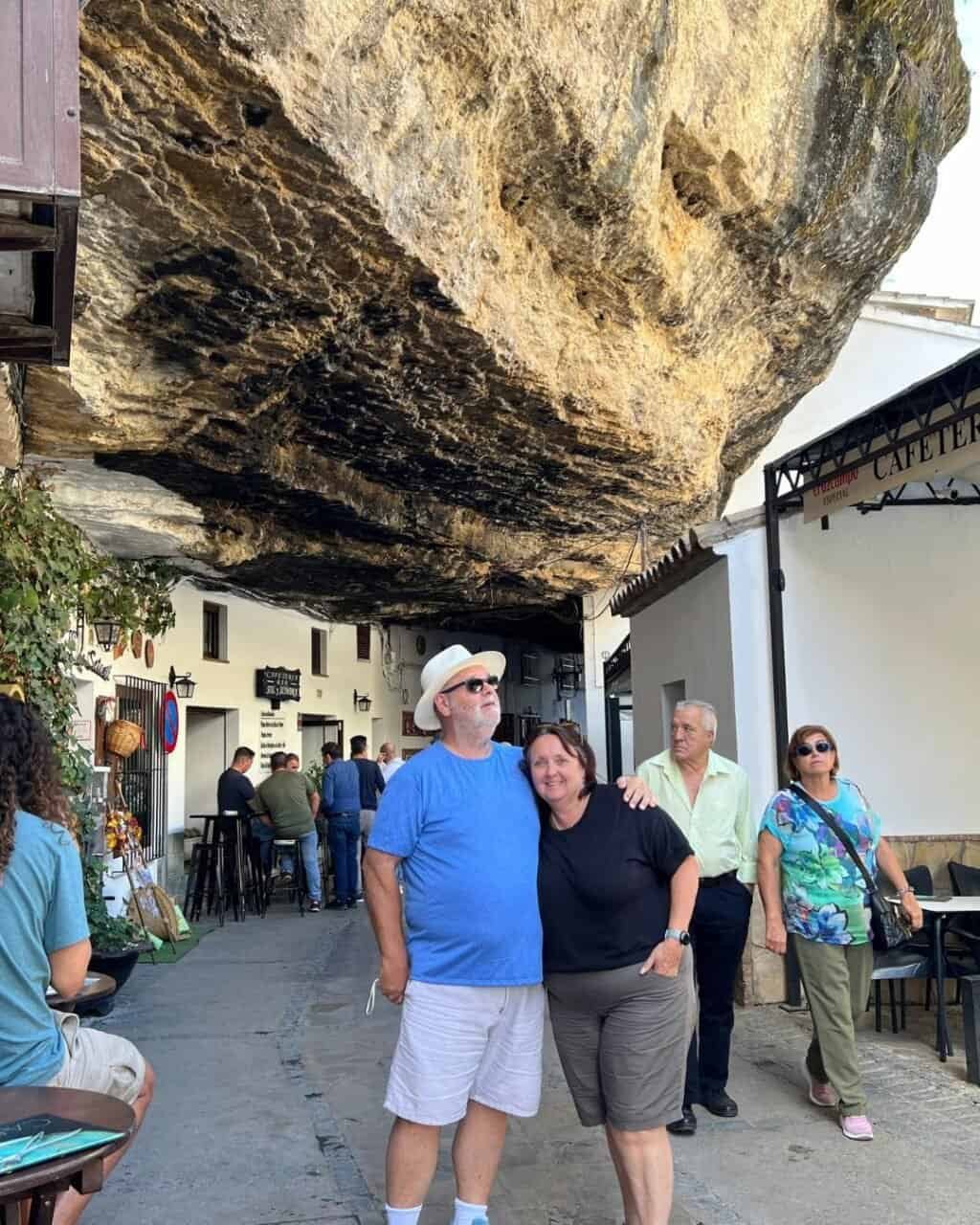 couple stading under the rocks on one of the famous streets of setinel de las bodegas