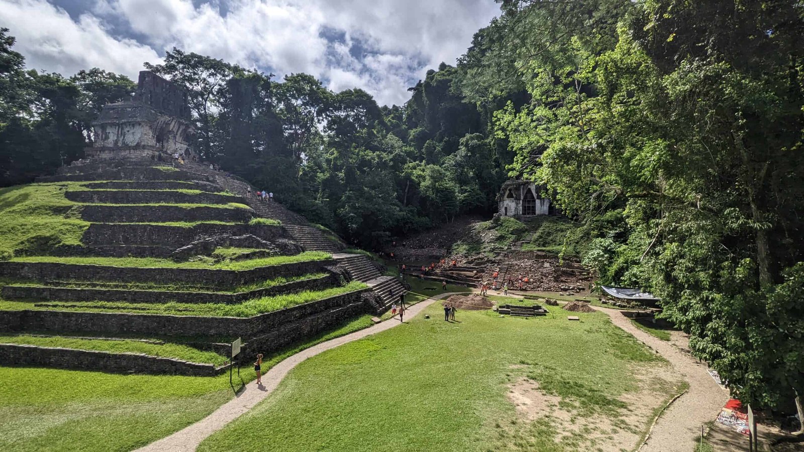 looking across green grass to one of the pyramids in the Palenque Mayan city