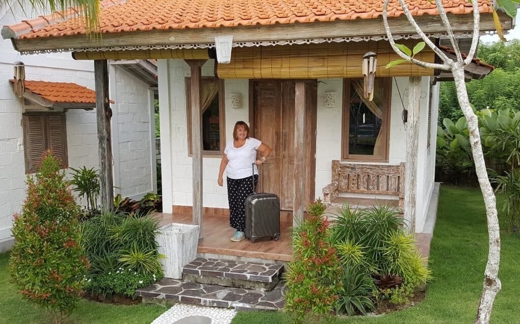 woman with suitcase on balcony of villa in uluwatu bali
