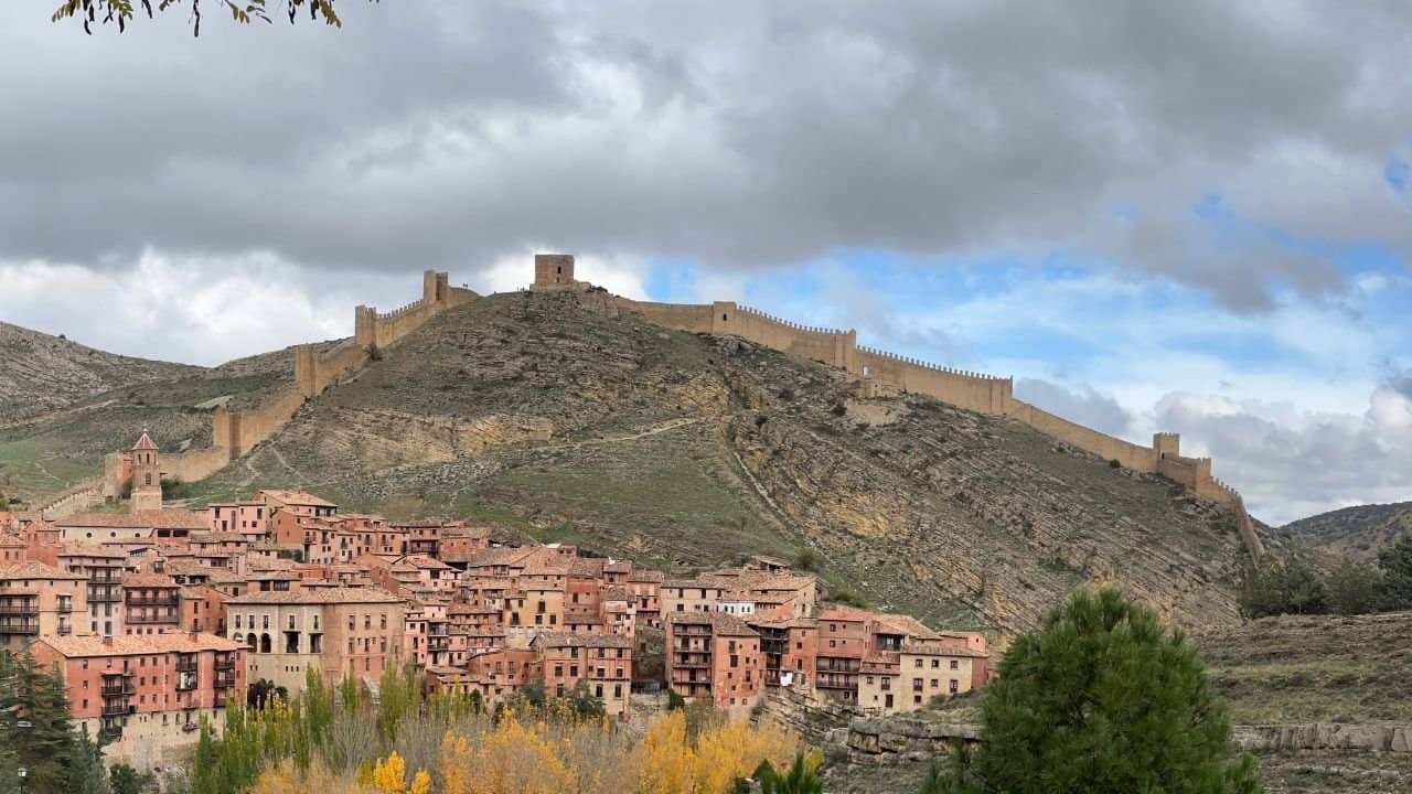 Historic Spanish fortress overlooking traditional hillside village in Spain.